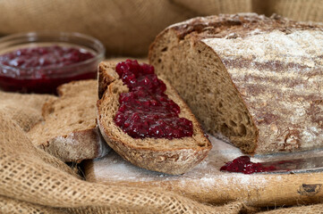 Rye bread slices spread with fruit jam and knife at near with jam on it
