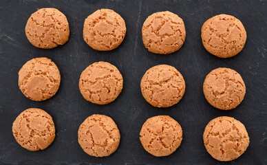 Italian Christmas cookies amaretti.Tasty Italian amaretti biscuits on black stone background.
Amarettini cookies.Selective focus.