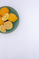 Citrus background, lemon in a bowl. Top view with lemon theme on white background.
