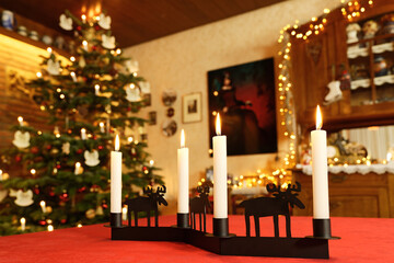 Rentier-Adventskerzen im Weihnachtszimmer, mit  Weihnachtsbaum und Weihnachtsbeleuchtung