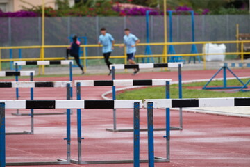 Synthetic running track for sporting events with hurdles