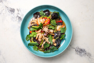 seafood and greens salad in a blue plate top view