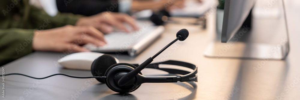 Aufkleber panorama focus headset on call center workspace desk with blur background of operator team or telesa