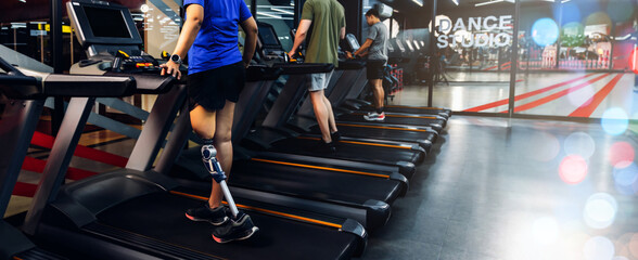 Sports woman with artificial leg running on treadmill at gym.