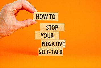 Stop negative self-talk symbol. Concept words How to stop your negative self-talk on wooden block. Psychologist hand. Beautiful orange background. Psychological negative self-talk concept. Copy space