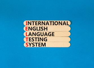 IELTS symbol. Concept words IELTS international english language testing system on wooden stick. Beautiful blue background. Business IELTS international english language testing system concept.