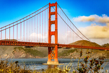 Fototapeta na wymiar Golden Gate Bridge in the city of San Francisco, in the state of California in the USA, crossing the bay and under a blue sky and beautiful clouds. Concept America.
