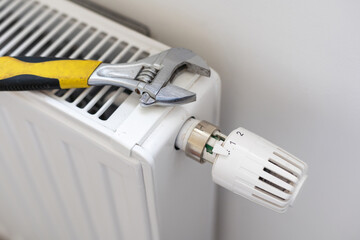 tightens the nut on the radiator with an adjustable wrench