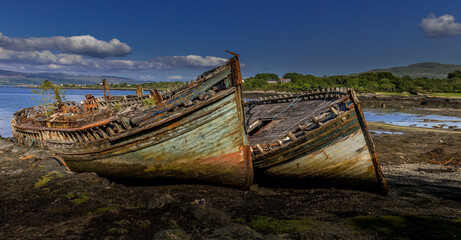 Fototapeta na wymiar Salen's 3 ships - iconic boat wrecks on the shore line on the Isle of Mull