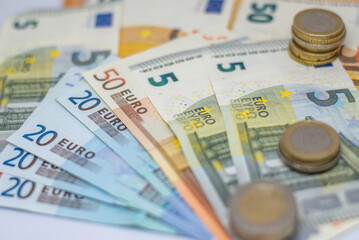 View of euros bank notes and coin. Bank notes of twenty, fifty, ten and five euros as well as one and two euros coins are seen piled up
