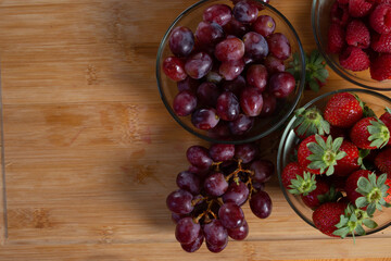 bunch of eco - grapes from southafrica sable over a wood table