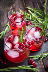 Glasses of currant juice on a black stone board and a wooden table.