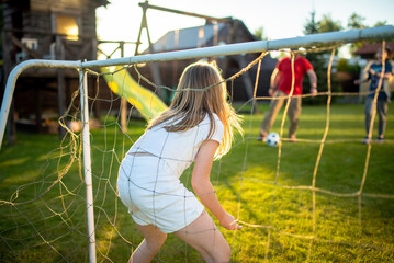 Cute young soccer player having fun playing a soccer game on sunny summer day. Preteen girl playing sports games outdoor.