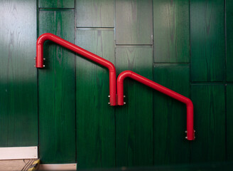 Red railing on green wooden wall. Interior
