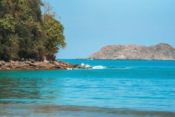 Scenic view of cliff surrounded with beautiful pacific ocean under clear blue sky during sunny day at Costa Rica, nature and travel concept