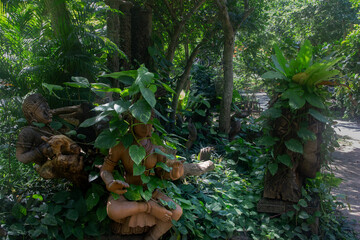 Wooden buddha statue among plants, Buddha in nature, Pattaya, Thailand
