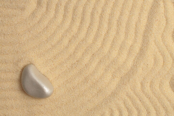 Fototapeta na wymiar Stone on wave sand. Nature background.