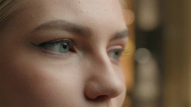 Close up macro view female blue eyes unrecognizable woman human face in details with eyeliner makeup. Girl looking in distance watching focused sight eye vision eyesight laser correction healthcare