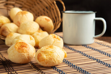 Cheese bread, Basket with cheese bread lying on a wooden woven mat and accessories, dark background, selective focus.