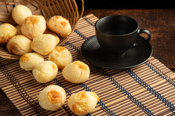 Cheese bread, Basket with cheese bread lying on a wooden woven mat and accessories, dark background, selective focus.
