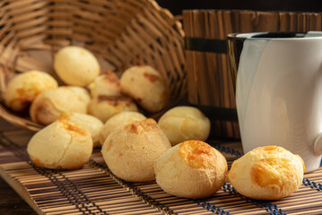 Cheese bread, Basket with cheese bread lying on a wooden woven mat and accessories, dark background, selective focus.