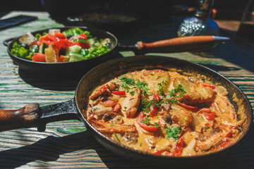 Fried potatoes with red sweet pepper seasoned with herbs served in a frying pan.