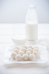 Morning breakfast, coconut cookies and fresh milk in a bottle and glass on the table.