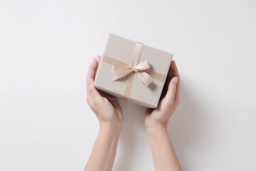 Grey giftbox in woman hands, top view, light background. Generative AI