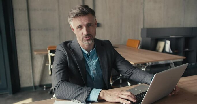 Guide from a 40 year old red-haired man in a business suit in the office. man looking at camera