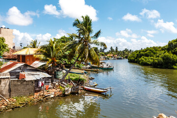 Fototapeta na wymiar Canal with Sri Lankan houses and fishing boats in Negombo, Sri Lanka, Asia