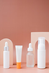 set of skincare containers on a pastel display background.