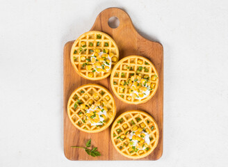 Vegan Round Corn waffles. On a wooden board. White background. Top view