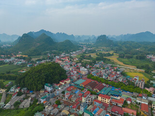 Fototapeta na wymiar Aerial top view of fresh paddy rice terraces, green agricultural fields in countryside or rural area of Cao Bang, Urban city town, mountain hills valley in Asia, Vietnam, China border.Nature landscape
