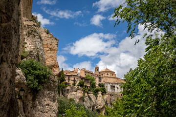 Beautiful partial view between trees and rocks of the Unesco heritage monumental city of Cuenca, Spain