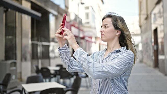 Young blonde woman smiling confident make photo by smartphone at coffee shop terrace