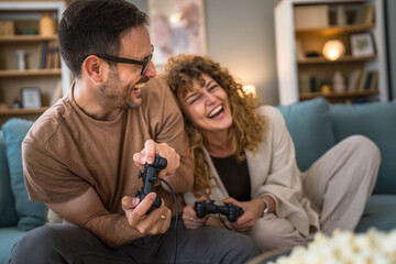 couple man and woman husband wife play console video games at home © Miljan Živković
