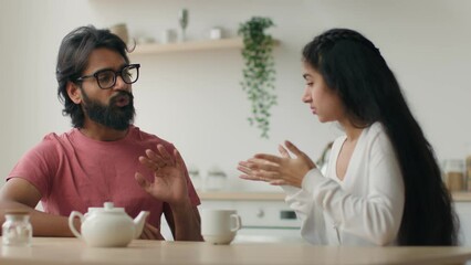 Family conflict couple quarrel Arabian Indian husband and wife arguing talking in home kitchen stressed annoyed man and woman talk loud solve disagreement misunderstanding argue relationship problem - Powered by Adobe