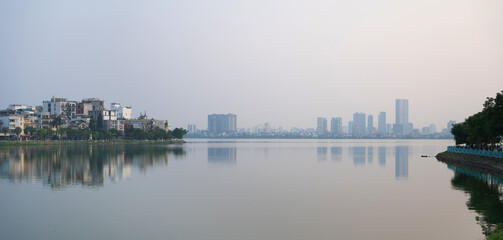 Fototapeta premium Reflection of Hanoi Downtown Skyline, Vietnam with lake and river. Financial district and business centers in smart urban city in Asia. Skyscraper and high-rise buildings.