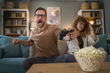 couple man and woman husband wife play console video games at home © Miljan Živković