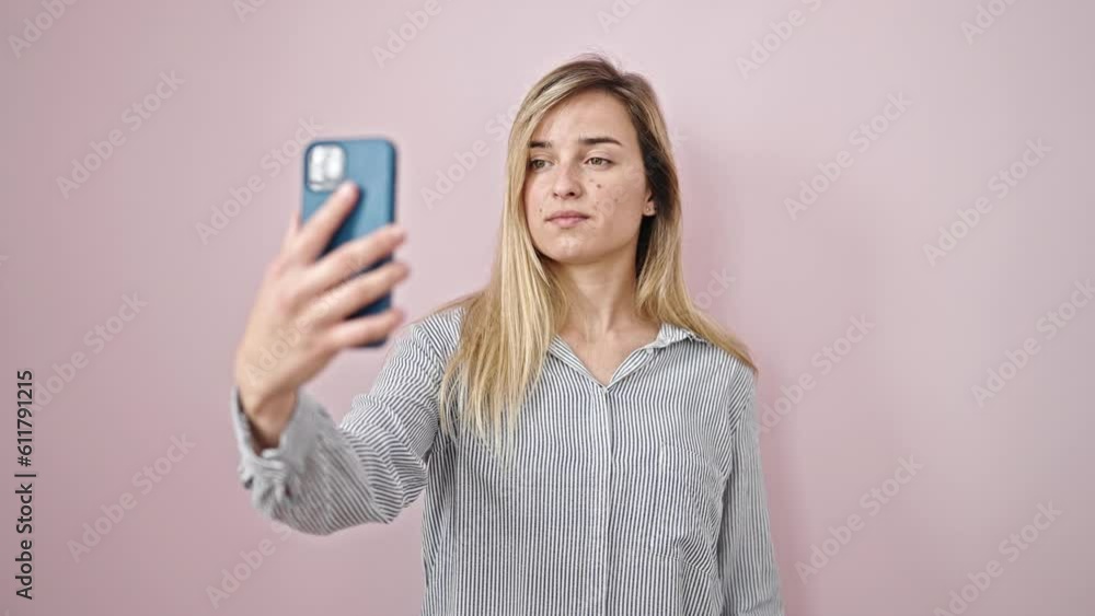 Sticker young blonde woman smiling confident making selfie by the smartphone over isolated pink background