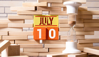 Vintage photo, July 10th. Date of 10 July on wooden cube calendar, copy space for text on board