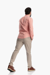 behind view of young man in plaid shirt holding hand in pocket and walking