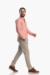 side view of attractive bearded man looking away and walking