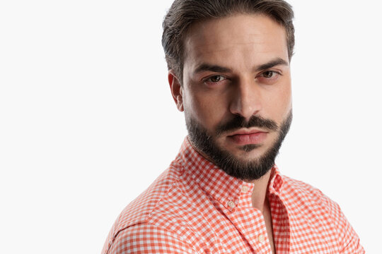 close up picture of attractive bearded man in plaid shirt looking forward