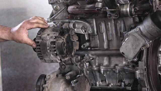 Tightening the Alternator Charger Screws of the Faulty Old Car Engine in the Repair Shop Footage.