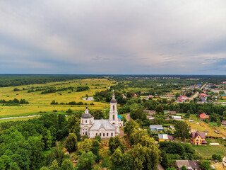 Fototapeta na wymiar Landscape with orthodox church with fields under gloomy sky