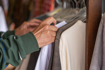 Men's hands on the background of hangers with men's clothing , Greece, Crete