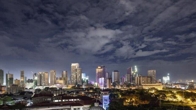 Time lapse of the clouds moving above the buildings in Manila, Philippines.