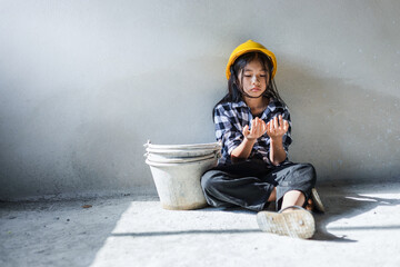 Child labor girl looking her dirty hands from construction work. World Day Against Child Labour...