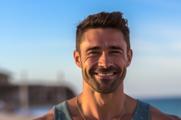 Fototapeta na wymiar Portrait of handsome man smiling at camera on the beach at sunrise